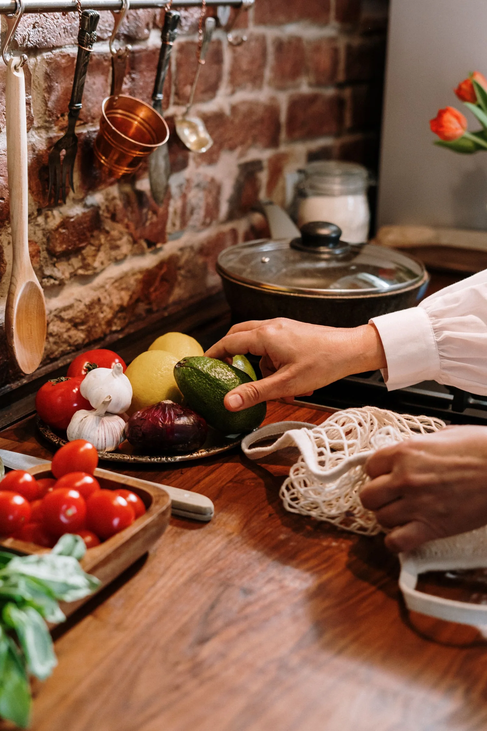 Hands preparing fresh vegetables on a kitchen work surface.