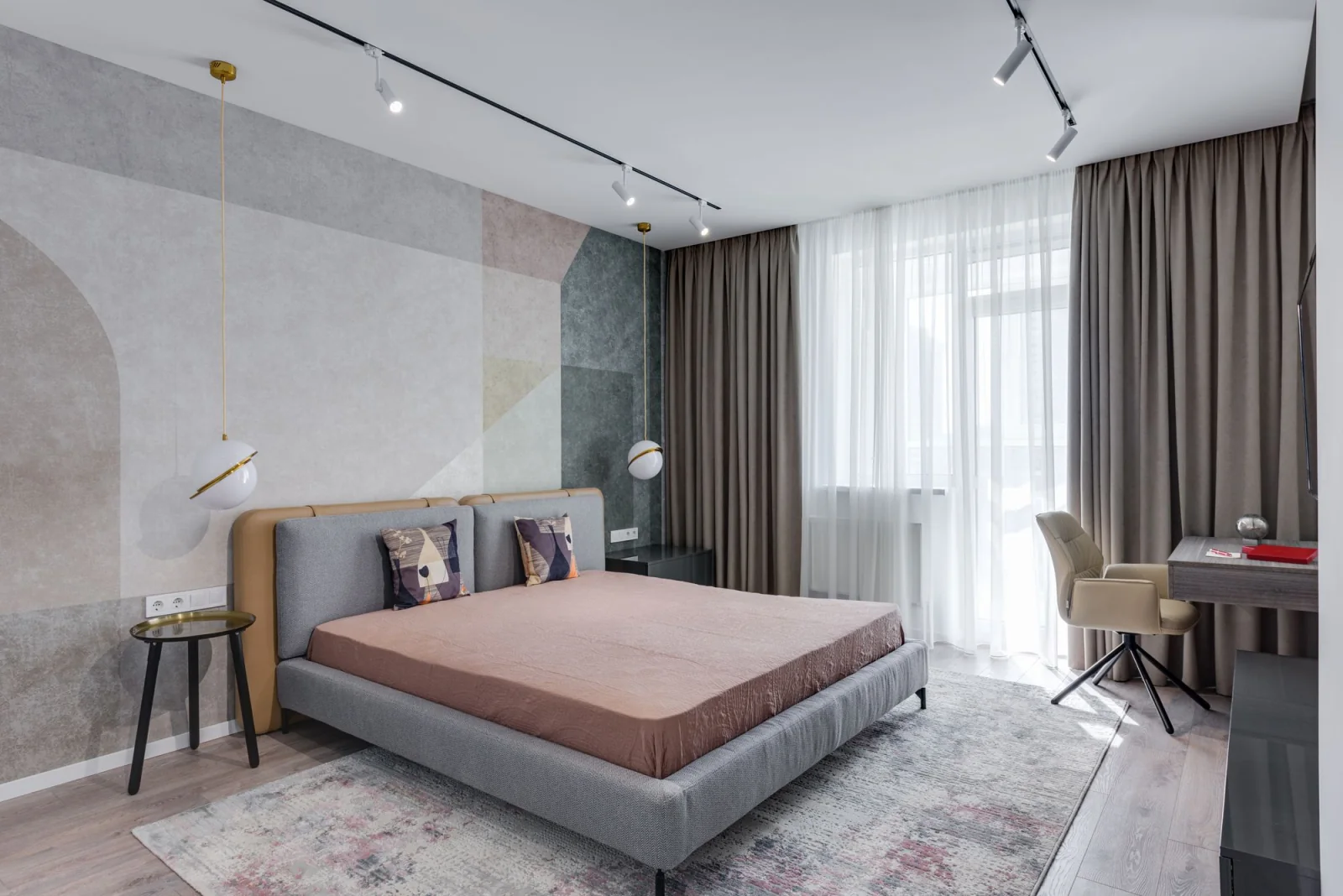 Calm bedroom with an upholstered bed, window light and a reading chair.